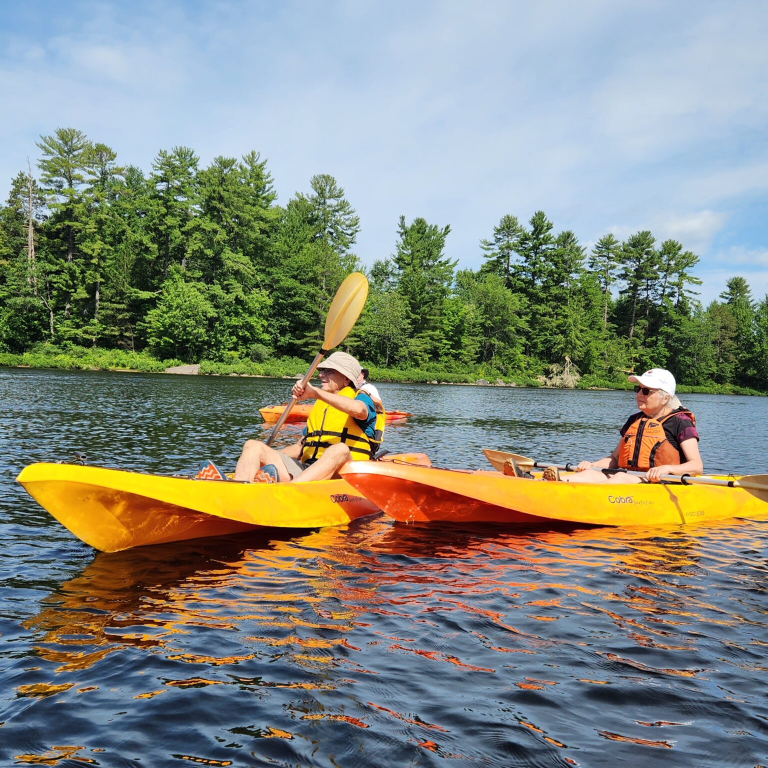 Two people paddling kayaks in water
